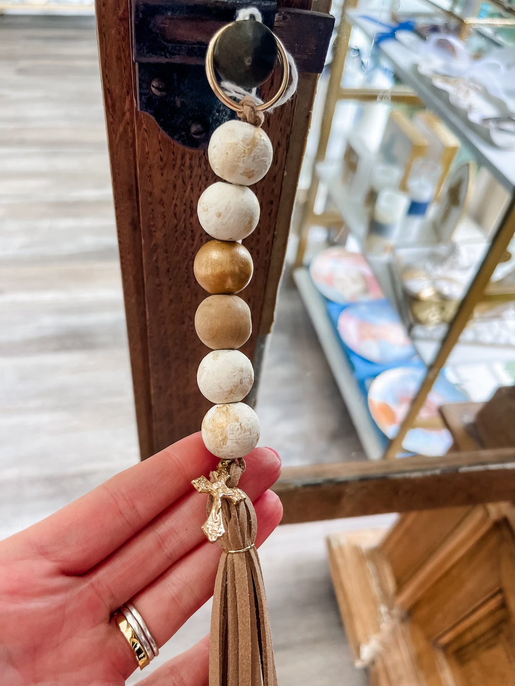 White, gold and wood bead keychain with crucifix and leather tassle-Stretched Out Designs By Chelse Breaux