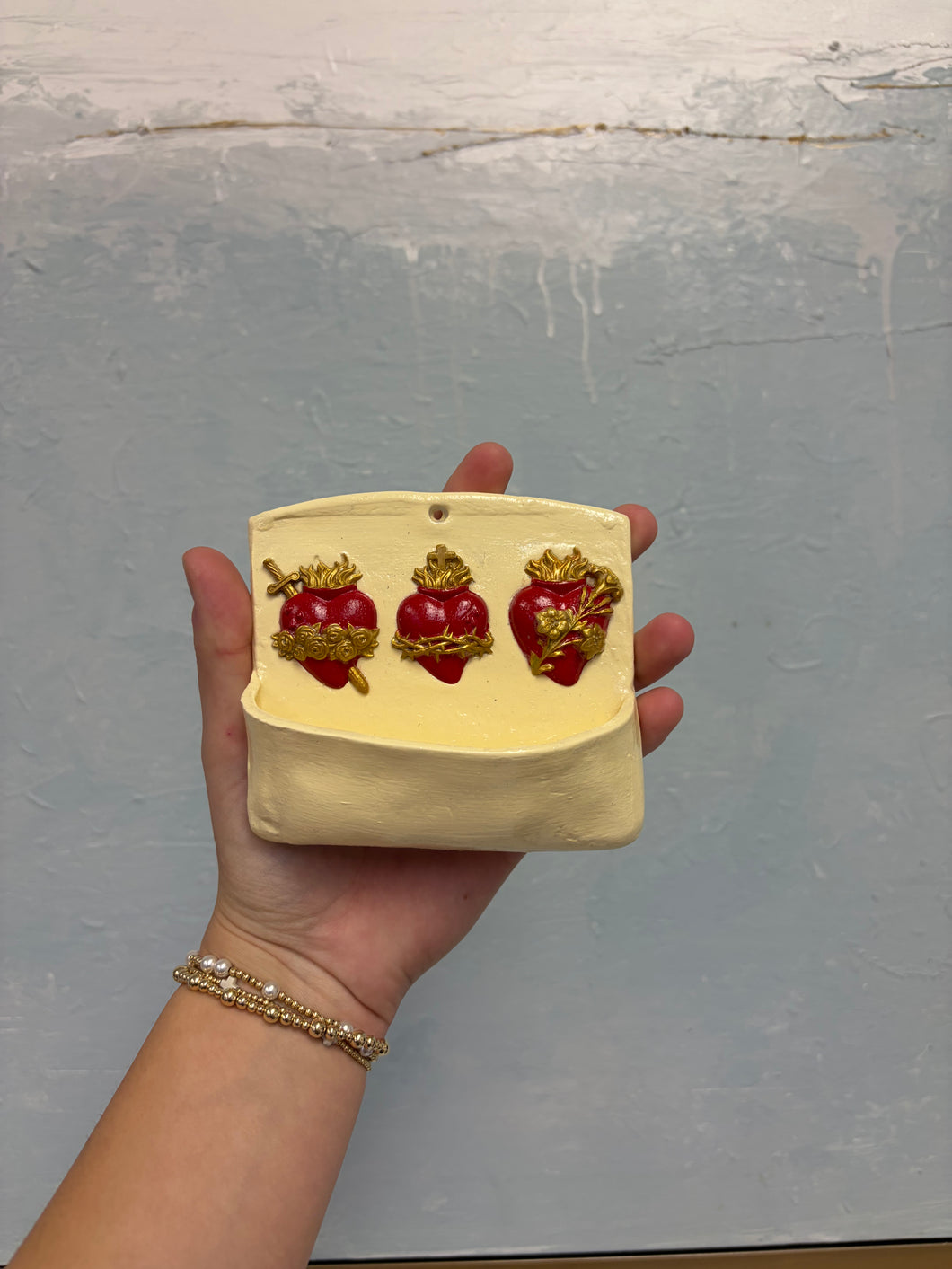 Red and white holy hearts water font - Mary Abraham Collective
